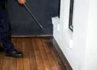 A pest control technician applying year-round residential spray Phoenix homes need along the exterior perimeter and entry points.