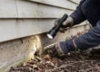 Technician inspecting a home foundation entry point as part of a year-round pest control plan in Phoenix